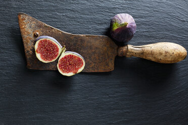 Sliced and whole fig and rusty cleaver on slate - CSF28302