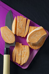 In Scheiben geschnittene Süßkartoffel auf Schneidebrett - CSF28313