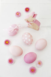 Hand dyed pink Easter eggs with bunny and daisy decoration on wooden background - GWF05265