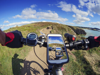 Frankreich, Bretagne, Sainte-Anne la Palud, Plage de Treguer, Handy auf E-Bike - LAF01909