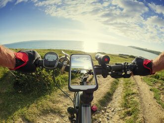 Frankreich, Bretagne, Sainte-Anne la Palud, Plage de Treguer, Handy auf E-Bike - LAF01910