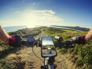 France, Bretagne, Sainte-Anne la Palud, Plage de Treguer, cell phone on mountain e-bike - LAF01911