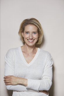 Portrait of laughing blond woman in front of light background - PNEF00006