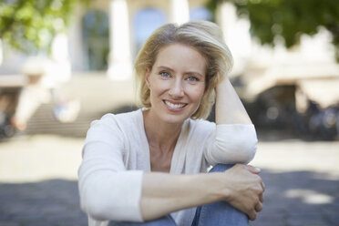 Portrait of smiling blond woman with hand in her hair - PNEF00013