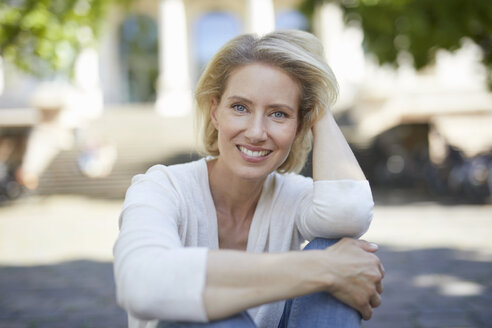 Porträt einer lächelnden blonden Frau mit einer Hand in ihrem Haar - PNEF00013