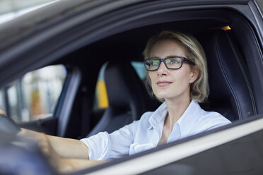 Blonde Geschäftsfrau mit Brille fährt Auto - PNEF00038