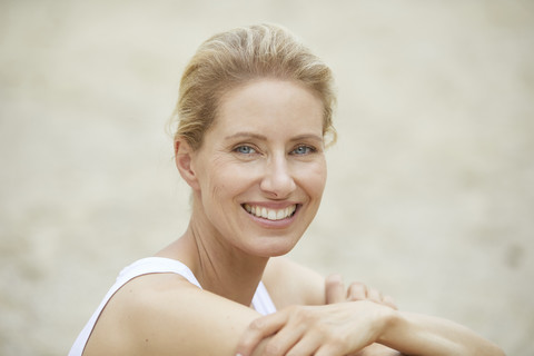 Porträt einer lachenden blonden Frau am Strand, lizenzfreies Stockfoto