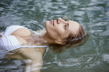 Portrait of relaxed woman floating on water - PNEF00049