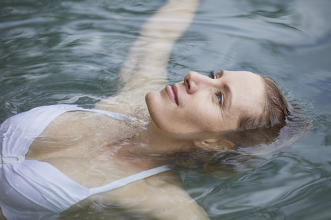 Portrait of relaxed woman floating on water stock photo