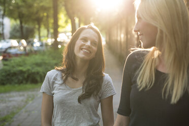 Zwei glückliche junge Frauen im Freien bei Sonnenuntergang - PNEF00054