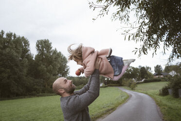 Father holding little daughter aloft - KMKF00010