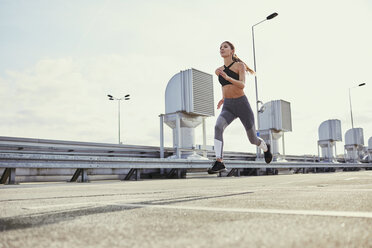 Young woman running in the city - BSZF00056