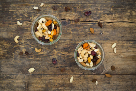 Two glasses of trail mix on dark wood stock photo