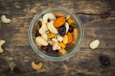 Glass of trail mix on dark wood - LVF06328