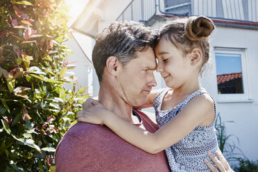 Father holding daughter in front of their home - RORF01020