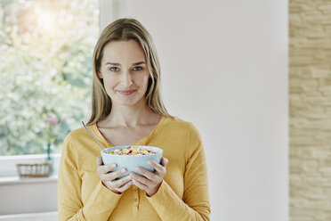 Portrait of woman holding bowl with muesli - RORF01029