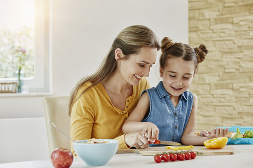Happy mother with daughter at home cutting vegetables - RORF01030