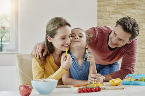 Glückliche Familie zu Hause bei der Zubereitung gesunder Speisen - RORF01033