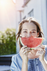 Porträt einer glücklichen Frau mit einer Scheibe Wassermelone im Freien - RORF01047