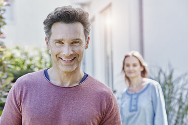 Portrait of smiling man with woman in background - RORF01054