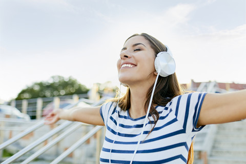 Happy young woman wearin headphones enjoying the summer stock photo