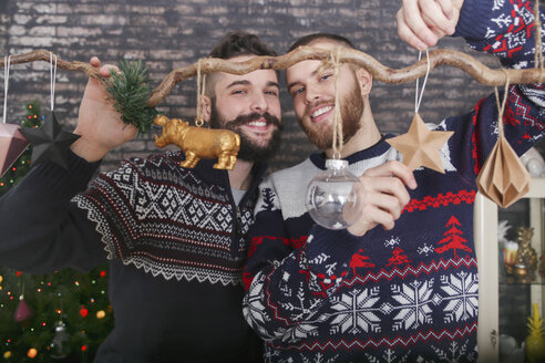Schwules Paar schmückt einen Zweig zur Weihnachtszeit - RTBF01033