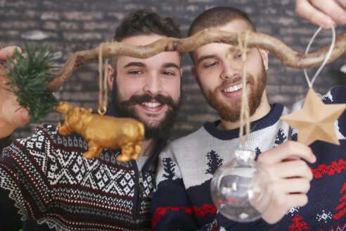 Schwules Paar schmückt einen Zweig zur Weihnachtszeit - RTBF01034