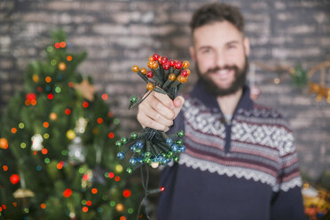 Man holding chain of lights, close-up - RTBF01045