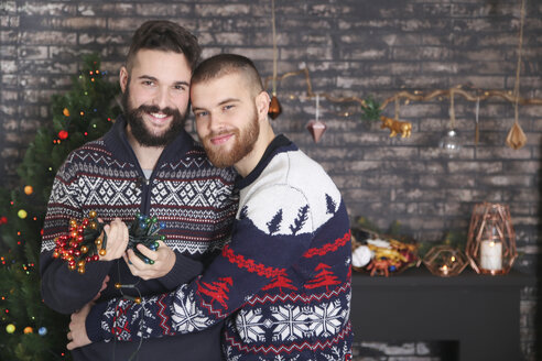 Porträt eines glücklichen schwulen Paares mit Lichterkette zur Weihnachtszeit - RTBF01046