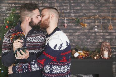 Küssendes schwules Paar mit Lichterkette zur Weihnachtszeit zu Hause - RTBF01047