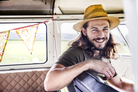 Porträt eines glücklichen jungen Mannes in einem Lieferwagen, lizenzfreies Stockfoto