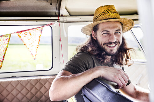 Portrait of happy young man inside a van - FMKF04526