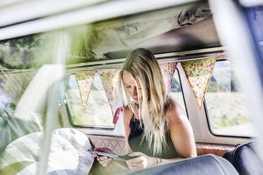 Frau benutzt Tablet in einem Lieferwagen - FMKF04536