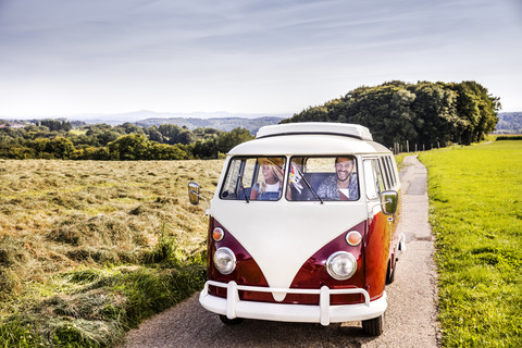 Happy couple inside van in rural landscape stock photo