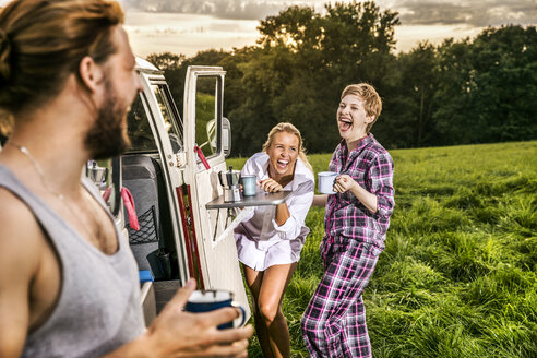 Sorglose Freunde genießen Kaffee an einem Lieferwagen in ländlicher Landschaft - FMKF04596