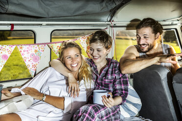 Happy friends inside a van enjoying coffee - FMKF04597