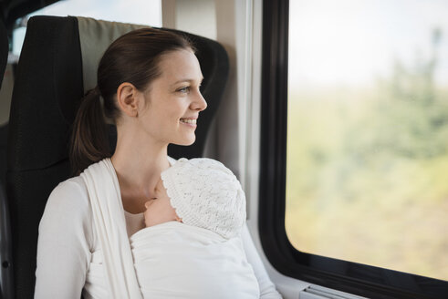 Mutter mit kleinem Mädchen reist mit dem Zug und schaut aus dem Fenster - DIGF02868