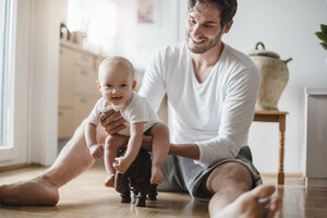 Glücklicher Vater mit spielendem Mädchen zu Hause - DIGF02879