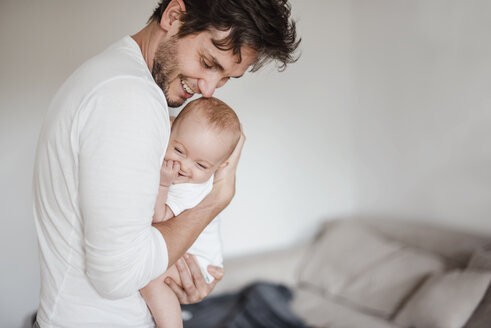 Father holding baby girl at home - DIGF02881