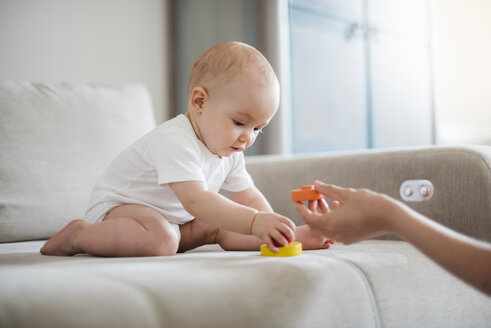 Baby Mädchen spielt auf der Couch zu Hause - DIGF02897