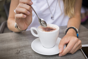 Nahaufnahme einer Frau mit Cappuccino in einem Straßencafé - JUNF00919