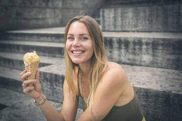 Portrait of happy young woman holding ice cream cone - JUNF00924