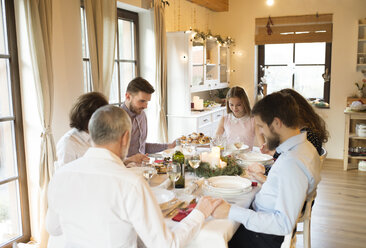 Family praying before Christmas dinner - HAPF02188