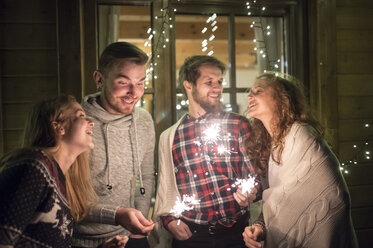 Glückliche Freunde halten nachts im Freien Wunderkerzen - HAPF02221