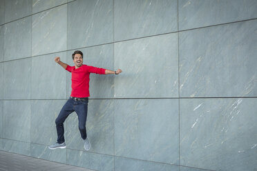 Active man jumping for joy, cheering - JUNF00960