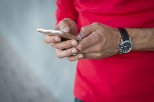 Hände eines Mannes, der eine Textnachricht auf einem Smartphone schreibt - JUNF00963