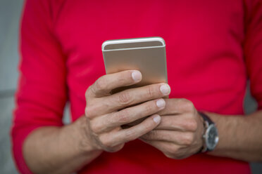 Hands of man writing text message on a smartphone - JUNF00964