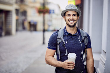 Porträt eines Reisenden mit Rucksack und Kaffee - BSZF00082