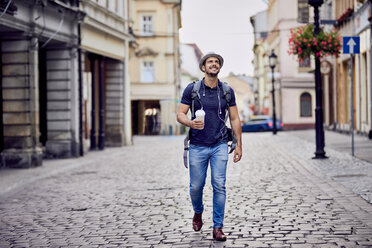 Traveler with backpack and coffee admiring the architecture - BSZF00083