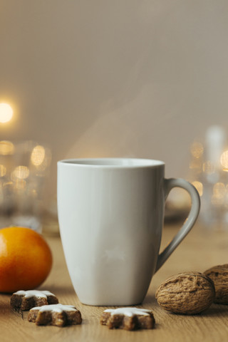 Tasse mit heißem Tee, Mandarine, Walnüssen und Zimtsternen, lizenzfreies Stockfoto